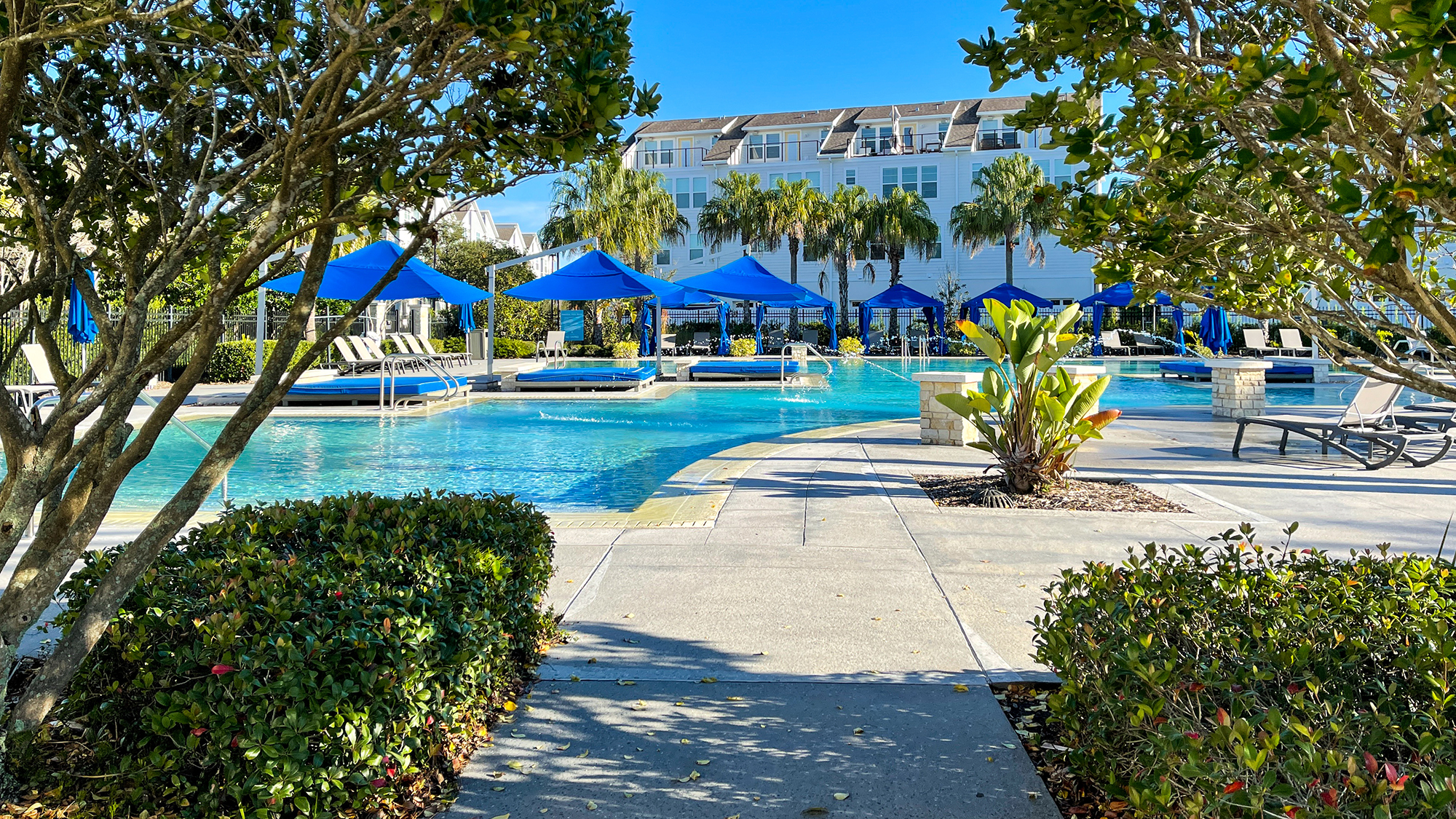 Orlando, FL USA  - January 4, 2021: A neighborhood amenity complex pool that looks like a resort with palm trees, water jets  and cabanas.